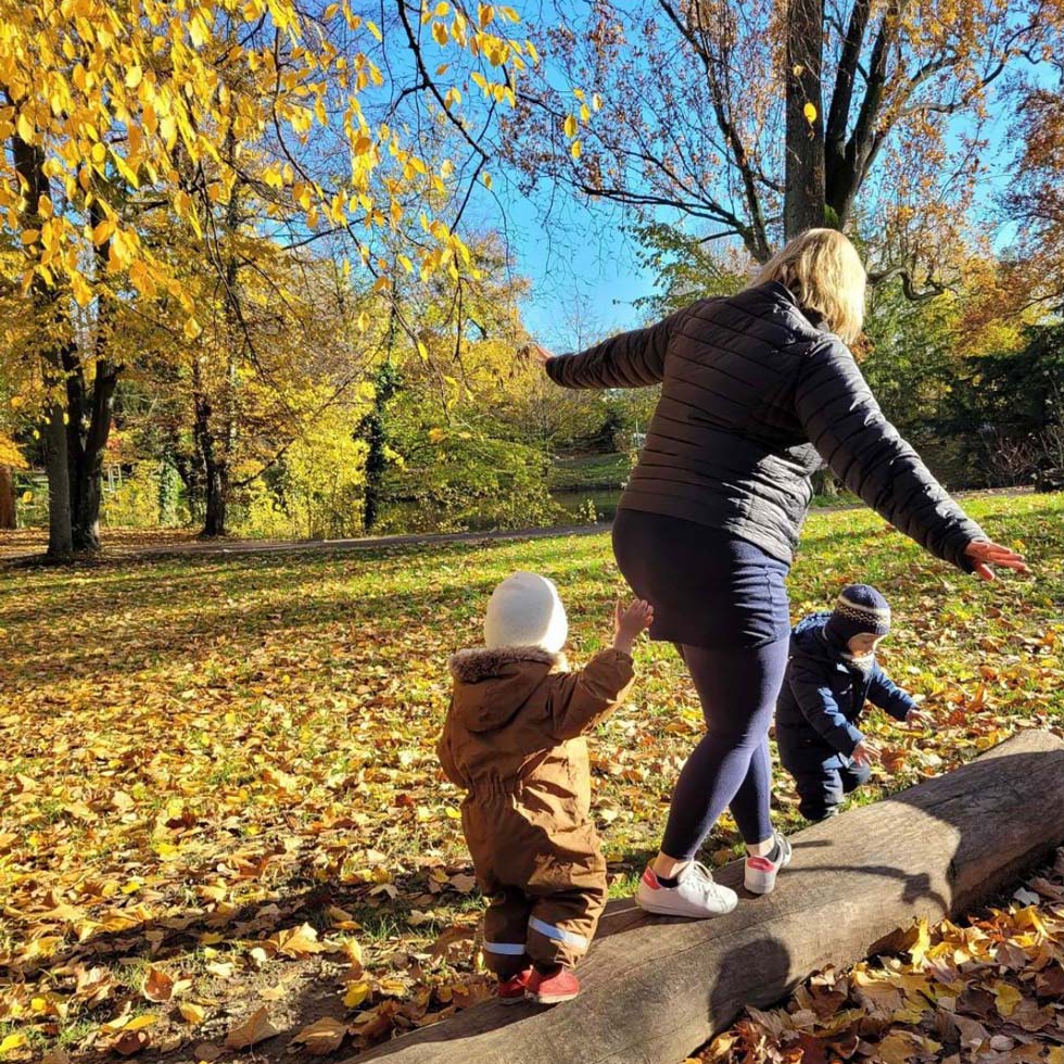 Photo d'une monitrice et d'un enfant jouant sur une poutre